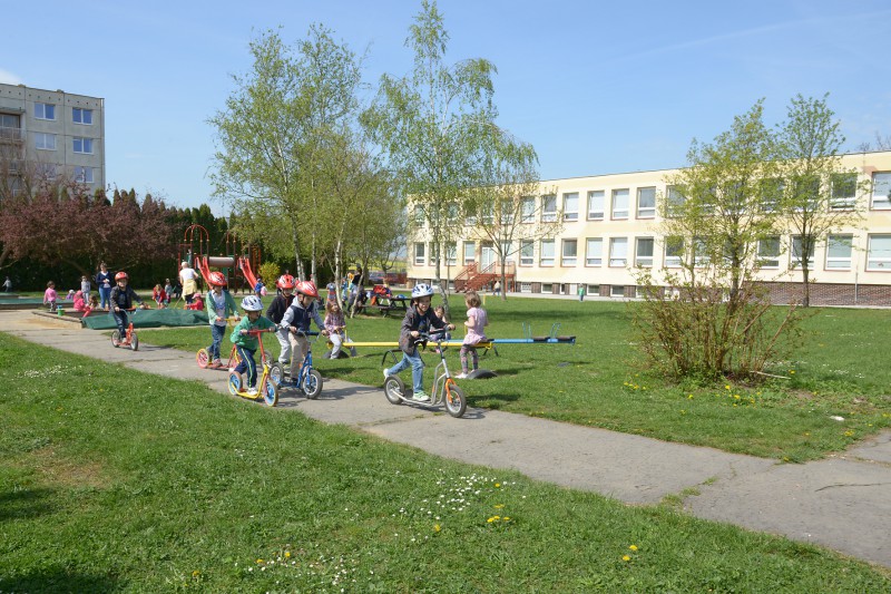 Školka Sluníčko – pohled na zahradu mateřské školy s houpačkami, klouzačkou, pískovištěm, zpevněným povrchem pro jízdu na koloběžkách   