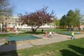 MŠ Sluníčko – pohled na zahradu mateřské školy s  klouzačkou, pískovištěm, zpevněným povrchem pro jízdu na koloběžkách  